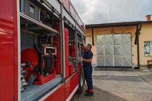 A dedicated firefighter preparing a modern firetruck for deployment to hazardous fire-stricken areas, demonstrating readiness and commitment to emergency response photo