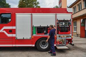 A dedicated firefighter preparing a modern firetruck for deployment to hazardous fire-stricken areas, demonstrating readiness and commitment to emergency response photo
