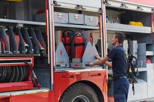 A dedicated firefighter preparing a modern firetruck for deployment to hazardous fire-stricken areas, demonstrating readiness and commitment to emergency response photo