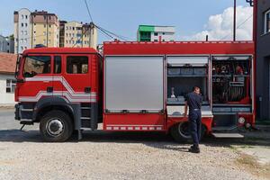 A dedicated firefighter preparing a modern firetruck for deployment to hazardous fire-stricken areas, demonstrating readiness and commitment to emergency response photo