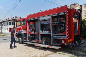 A dedicated firefighter preparing a modern firetruck for deployment to hazardous fire-stricken areas, demonstrating readiness and commitment to emergency response photo