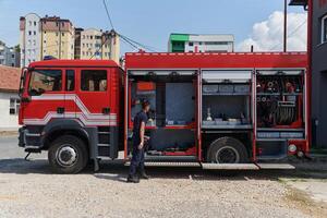 A dedicated firefighter preparing a modern firetruck for deployment to hazardous fire-stricken areas, demonstrating readiness and commitment to emergency response photo