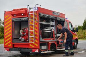 A dedicated firefighter preparing a modern firetruck for deployment to hazardous fire-stricken areas, demonstrating readiness and commitment to emergency response photo