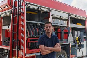 Confident firefighter stands with crossed arms, exuding resilience and preparedness, ready to respond to emergencies alongside a modern fire truck, showcasing the heroism and strength of the fire photo