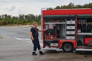 A dedicated firefighter preparing a modern firetruck for deployment to hazardous fire-stricken areas, demonstrating readiness and commitment to emergency response photo