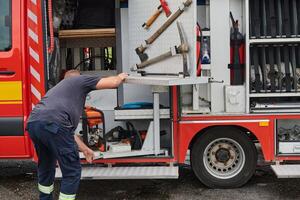 A dedicated firefighter preparing a modern firetruck for deployment to hazardous fire-stricken areas, demonstrating readiness and commitment to emergency response photo