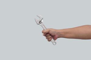 close up of hand hold a wrench. isolated on yellow background photo