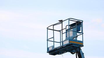 The aerial platform of the boom lift is carried to heights. with a bird perched on top photo