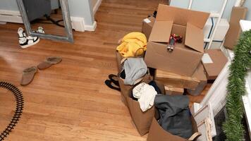 Cardboard boxes with clothes, shoes on the floor things and stuff for moving, photo