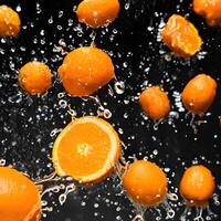 Fresh oranges splash into water, creating a vibrant burst of citrus goodness photo
