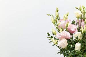 Bunch of beautiful multicolored eustoma flowers on neutral light background, space for text, invitation concept photo