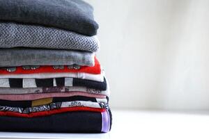 Stack of folded clothes on the table with copy space area photo