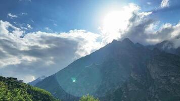 Sunlight breaks through the clouds against the background of the mountains video