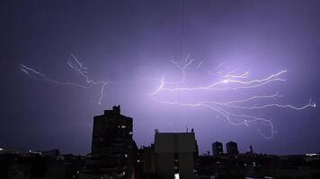 Lightning and thunder over the city at night, glaring and spectacular lightning, thunderstorms from window in near vintage skyscraper video