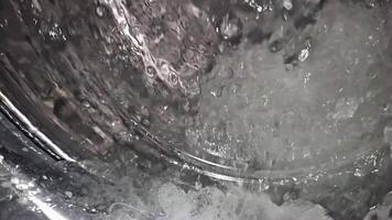 super slow-motion of water splashing in a washing machine, heavy interpolation artifacts in video
