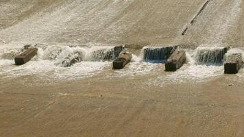 row of chute dentate blocks in concrete water spillway channel slope slowing down the flow of water running down video