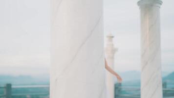 Person pointing behind marble columns video