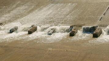 row of chute dentate blocks in concrete water spillway channel slope slowing down the flow of water running down video