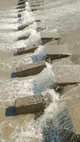 row of chute dentate blocks in concrete water spillway channel slope slowing down the flow of water running down video