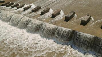 row of chute dentate blocks in concrete water spillway channel slope slowing down the flow of water running down video