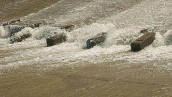 row of chute dentate blocks in concrete water spillway channel slope slowing down the flow of water running down video