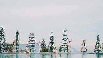 Synchronized dance by the pool with tall trees video