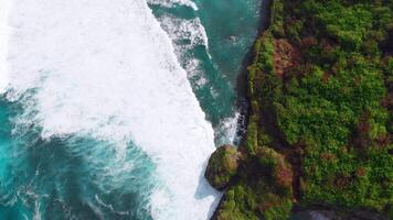 Scenic rock cliff and blue ocean with stormy waves. Drone view video
