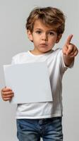 A young boy holding a piece of paper with excitement and wonder photo