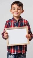 A young boy with a Latin smile holds a white board in his hands photo