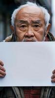 A sad Chinese man hides behind a blank sign photo