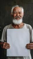 A Chinese elderly man with a peaceful smile holding a blank white sheet of paper photo
