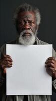 Mature man with afro holding a white paper over face photo