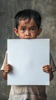 Young boy holds up a blank white sign, conveying a message of hope photo