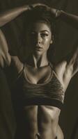 A female bodybuilder showcases her toned muscles and six-pack abs in a powerful pose photo