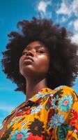 A Black woman with an afro looks up at the sky photo