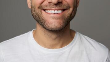 Close-up of a mans smiling mouth with white teeth against a gray background photo