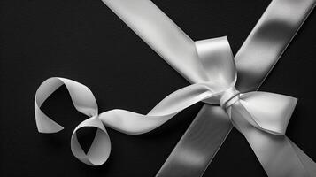 Top view flat lay of white ribbon bow on black background. Minimalist elegance concept. photo