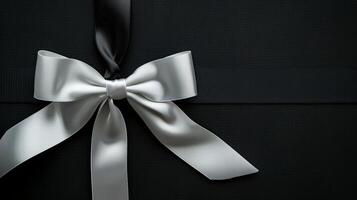 White ribbon bow arranged flatly on black background from top view. Elegance in simplicity. photo