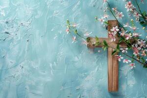 Wooden cross with spring flowers on blue background. Religious holidays. photo
