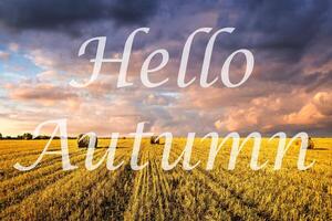 The words Hello Autumn on the background of field with golden haystacks. Greeting card. The concept of the beginning of autumn. photo