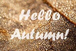 The words Hello Autumn on the background of autumn fallen leaf with dew drops. Greeting card. The concept of the beginning of autumn. photo