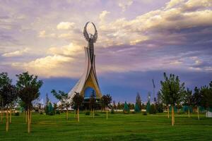 UZBEKISTAN, TASHKENT - AUGUST 15, 2023 Monument of Independence in the form of a stele with a Humo bird on a twilight in the New Uzbekistan park in summer. photo