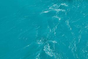 The texture of the waves of blue color of fast-flowing water in the river. photo