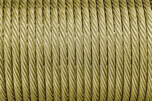 The texture of a new golden color cable wrapped in a spool. Abstract background. photo