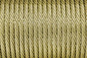 The texture of a new golden color cable wrapped in a spool. Abstract background. photo