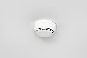 Smoke detector or fire alarm sensor on the ceiling. photo
