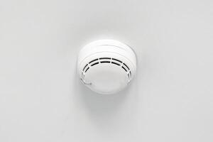 Smoke detector or fire alarm sensor on the ceiling. photo