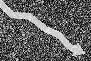 Arrow down on coal background. The concept of falling prices, mining, import, export, production or sales of coal. photo