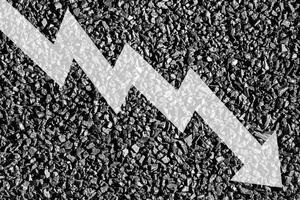Arrow down on coal background. The concept of falling prices, mining, import, export, production or sales of coal. photo