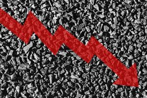 Arrow down on coal background. The concept of falling prices, mining, import, export, production or sales of coal. photo